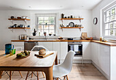 White Kitchen cabinets, with a dining table in the foreground