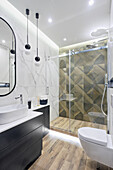 Elegant bathroom with marble tiles and shower cubicle