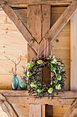 DIY wreath of tulips and branches of plum blossom on wooden beam
