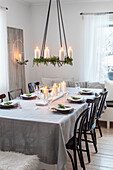 Dining table with festive decorations, hanging Advent wreath