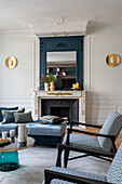 Living room with fireplace, wall mirror and patterned textiles