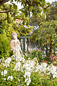 Frauenstatue in üppigem Garten