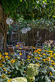 patio furniture with lanterns in flowering garden