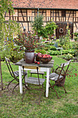 Seating area with hawthorn bouquet and apples in front of barn