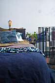 Patterned fabric in a bedroom in blue with banister to staircase
