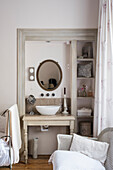 Small bathroom with vintage-style washbasin and round mirror
