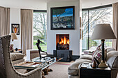 Living room with fireplace, large windows and modern art