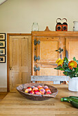 Landhausküche mit Holzschrank und Obstschale auf dem Tisch