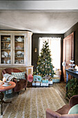 50s armchair with velvet cover, sideboard and decorated Christmas tree in living room