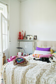 Helles Schlafzimmer mit Boho Tagesdecke, bunten Akzenten und Katze auf dem Bett