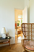 Bright room with herringbone parquet floors and vintage rattan chair