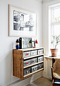 Wooden drawer wall unit with art in a bright room