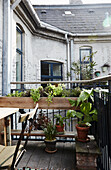 Wooden plant table with potted plants on urban balcony terrace