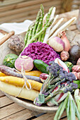 Colorful selection of vegetables in a rustic bowl on a wooden table