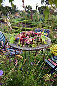 Hydrangea wreath on table in front of cottage garden