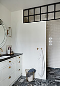 White bathroom with black surfaces and patterned floor tiles