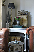Antique bric-a-brac on table behind vintage leather furniture