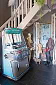 Retro jukebox and dressmaker's dummies in the hall below staircase
