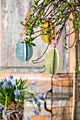 DIY Easter eggs made from book pages hanging from a branch