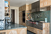 Küche mit Holzschränken, dunkelgrünen Fliesen und Granitarbeitsplatte