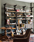 Wall of shelves with CDs, records and speakers, guitars and chess set in the foreground