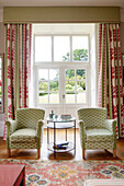 Classic living room with patterned fabric armchairs and floor-length curtains