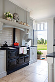 Country kitchen with black oven and view outside