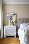 Elegant bedroom with patterned textiles, chest of drawers and wallpaper