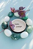 Springtime blossoms, message in wooden box and wreath made of Easter eggs