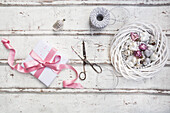 Christmas decoration, scissors and Christmas present on wood