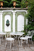 Classic garden chairs with tables in front of the wall, inspired by the Italian Renaissance