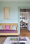 Yellow vintage sofa with patterned cushions, wall art in the living room