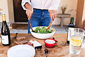 Woman making salad while standing by table at backyard