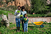 Happy family holding lettuce seedlings in a vegetable garden