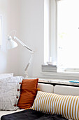 Schreibtischlampe über Sofa mit gestreiften und ockerfarbenem Kissen