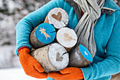 Woman carrying wooden logs decorated with Christmas motifs