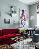 Rotes Samtsofa, großformatiges Kunstwerk über Bücherregal in eklektisch eingerichtetem Wohnzimmer