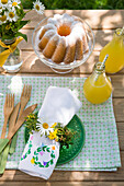 Laid garden table with cake and fresh lemonade in summer