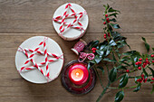 Christmas table decoration with red candles, holly and DIY boxes with stars