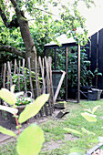 Rustikaler Zaun und Obstbaum im sommerlichen Gartenbereich