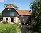 Former mill over stream and barn converted into home