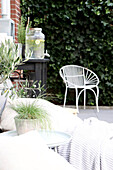 Terrassenecke mit weißem Metallstuhl und Grünpflanzen im Topf