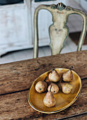 Keramikteller mit Birnen auf rustikalem Holztisch