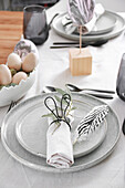 Easter decoration with feathers and eggs on a set table