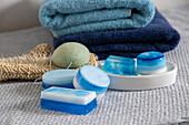 Homemade soaps in shades of blue, towels and exfoliating glove