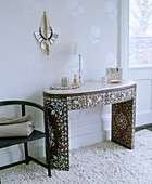 A detail of a modern bedroom showing a pearl inlaid dressing table wooden chair white long pile rug