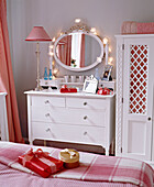 Bedroom with white painted chest of drawers and wardrobe and gingham soft furnishings