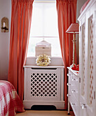 Bedroom with white painted chest of drawers and cabinet and gingham curtains