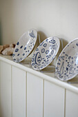 Three decorative plates on tongue and groove shelving in Rye kitchen, Sussex