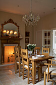 Dining chairs and table with fireplace and glass chandelier in Arundel, West Sussex
